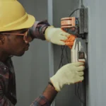 electrician installing wiring with yellow hardhat