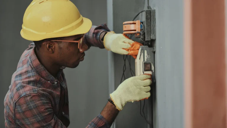 electrician installing wiring with yellow hardhat