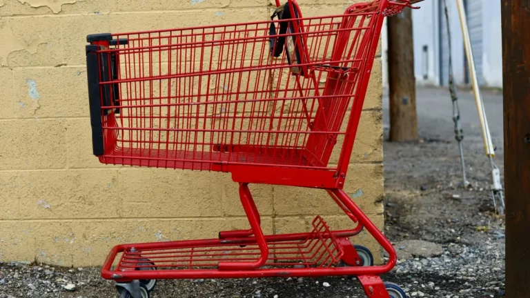 Empty red shopping cart against a yellow wall, illustrating Shopify abandoned cart recovery