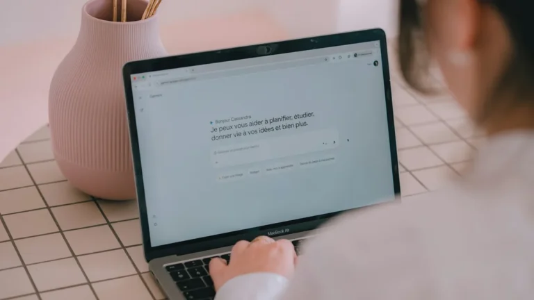 Person typing into a chat assistant on a laptop, illustrating Shopify AI tools