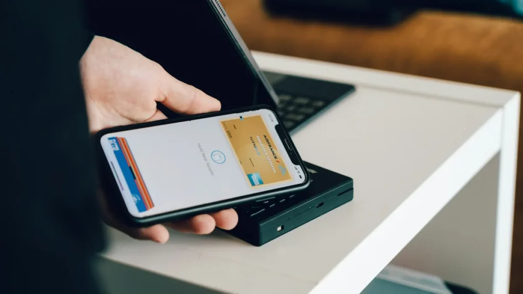 Hand holding a phone with a payment screen, illustrating Shopify checkout customization