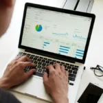 Hands on a laptop showing an analytics dashboard, illustrating Shopify conversion tracking