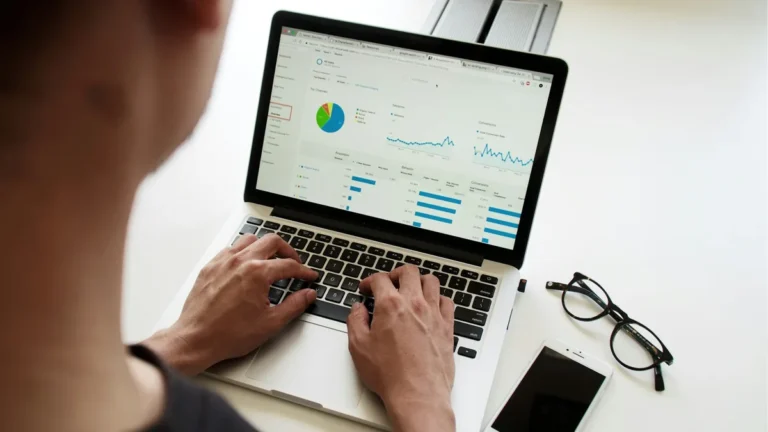 Hands on a laptop showing an analytics dashboard, illustrating Shopify conversion tracking