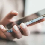 Hand holding a smartphone, illustrating follow-up messages from a Shopify and GoHighLevel integration