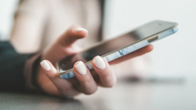 Hand holding a smartphone, illustrating follow-up messages from a Shopify and GoHighLevel integration