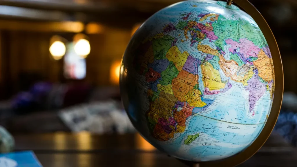 World globe in a warmly lit room, illustrating selling internationally with Shopify Markets