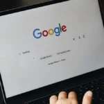 Laptop showing the Google search page beside a coffee mug, illustrating Shopify product schema