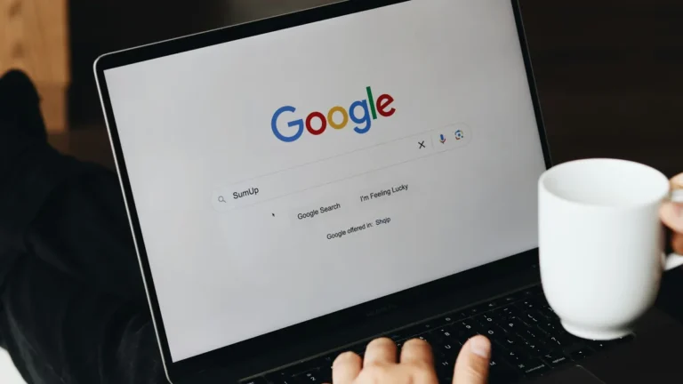 Laptop showing the Google search page beside a coffee mug, illustrating Shopify product schema