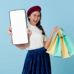 A woman holding a tablet computer and shopping bags