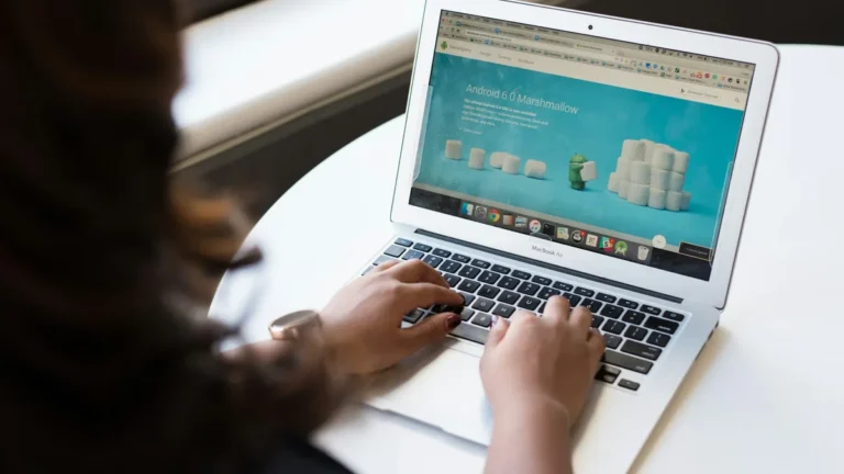 Hands typing on a laptop that shows an online store page, illustrating Shopify theme customization